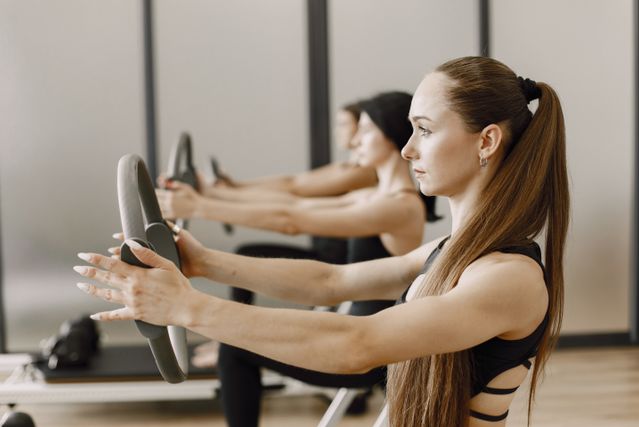 Plusieurs personnes faisant du pilates avec des anneaux